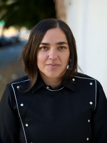 Josette Melchor against a white wall, direct gaze.