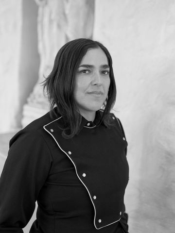 Josette Melchor, pensive, before a plaster sculpture.