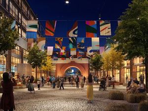 The Arnulfpost courtyard at night with hanging art banners and people gathered for an event.