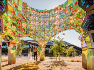 Visitors walking beneath Halo by SOFTlab — an iridescent dichroic-glass archway — at the Google Visitor Experience.