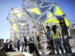 Participants assembling a lightweight tensile pavilion on a San Francisco street at the Urban Prototyping Festival.